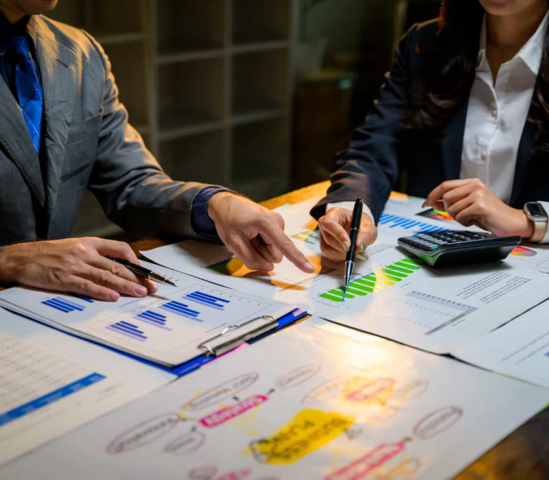 Profissionais analisando relatórios e gráficos para definir estratégias de vendas.